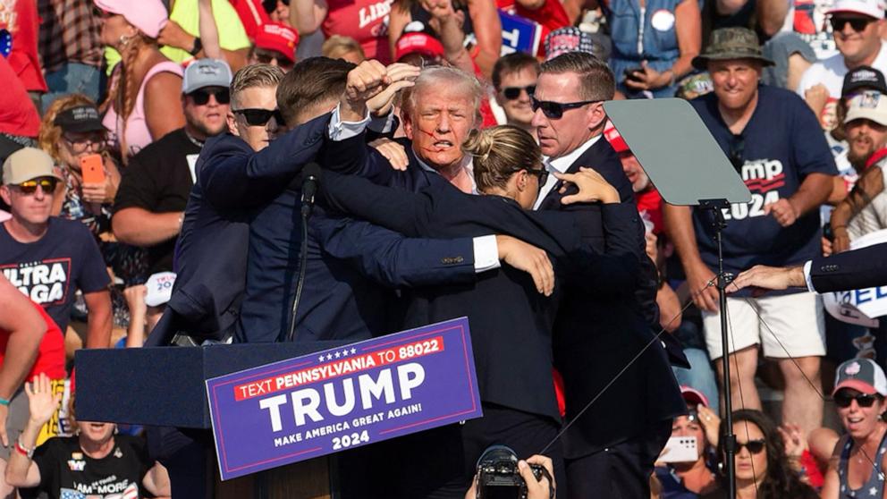 PHOTO: Republican candidate Donald Trump is seen with what appears to be blood on his face surrounded by secret service agents as he is taken off the stage at a campaign event in Butler, Pennsylvania, July 13, 2024.