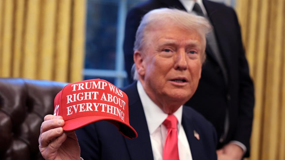 PHOTO: President Donald Trump holds up a hat stating "Trump Was Right About Everything" after signing executive orders in the Oval Office at the White House, Feb. 25, 2025 in Washington.