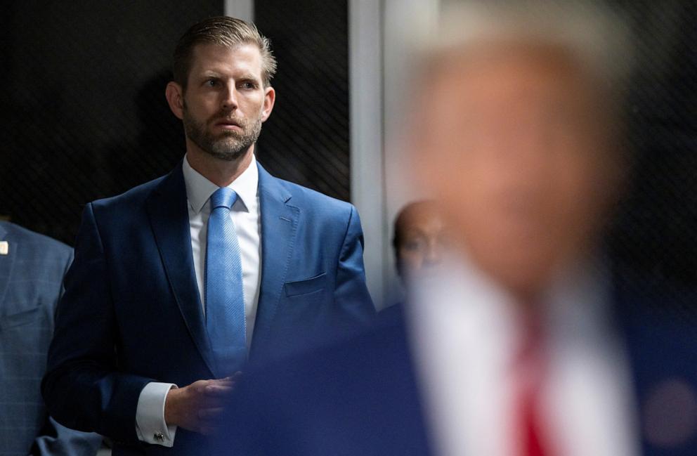PHOTO: Eric Trump listens as his father, former President Donald Trump, talks with the press as he arrives for his criminal trial at New York State Supreme Court in New York, Apr. 30, 2024. 