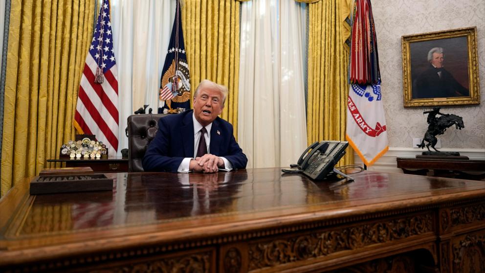 PHOTO: President Donald Trump answers questions from reporters as he signs an executive orders in the Oval Office of the White House, Jan. 23, 2025, in Washington.