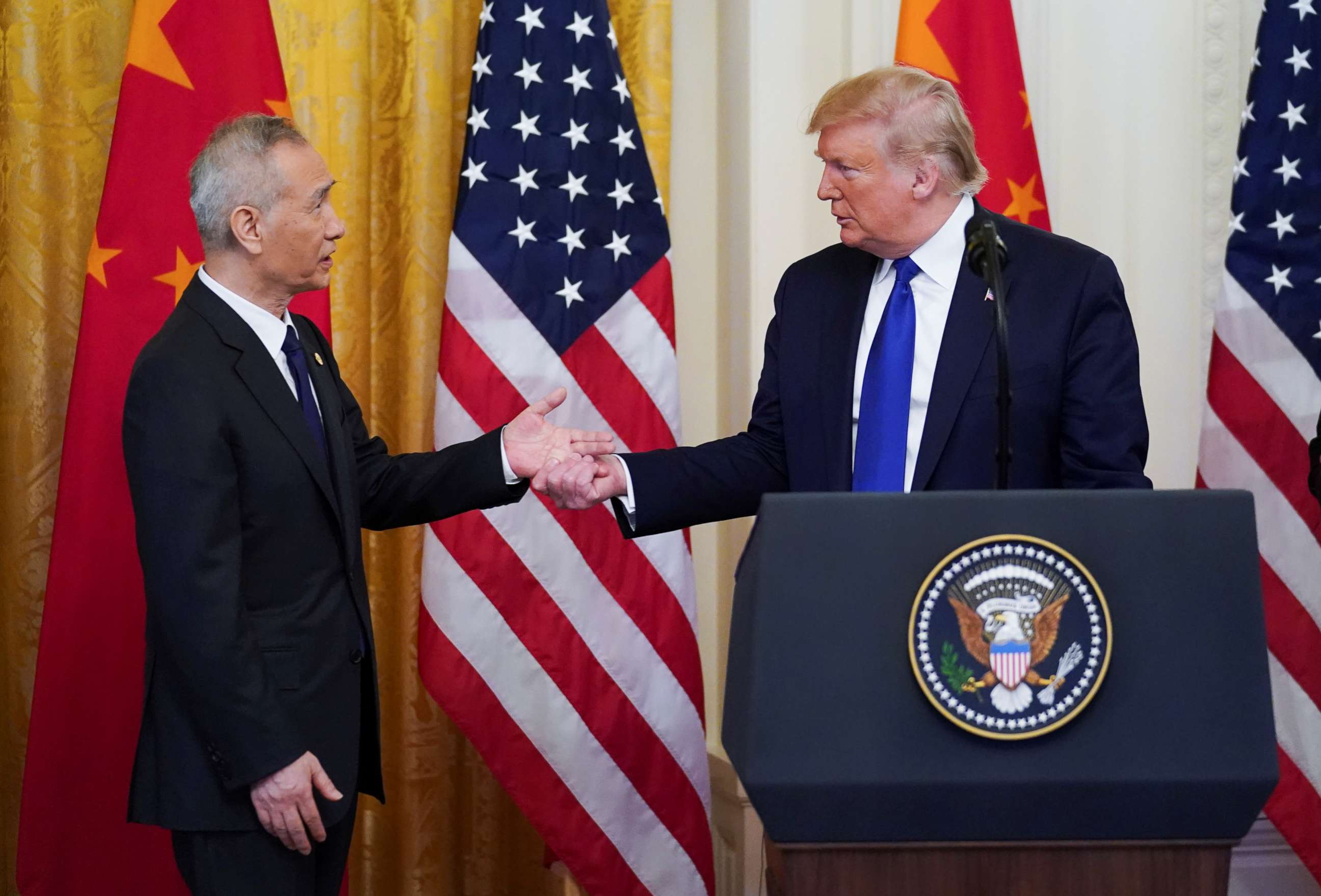 PHOTO: Chinese Vice Premier Liu He reaches out to President Donald Trump as he approaches the podium to speak during a signing ceremony for "phase one" of the U.S.-China trade agreement in the East Room of the White House in Washington, Jan. 15, 2020.