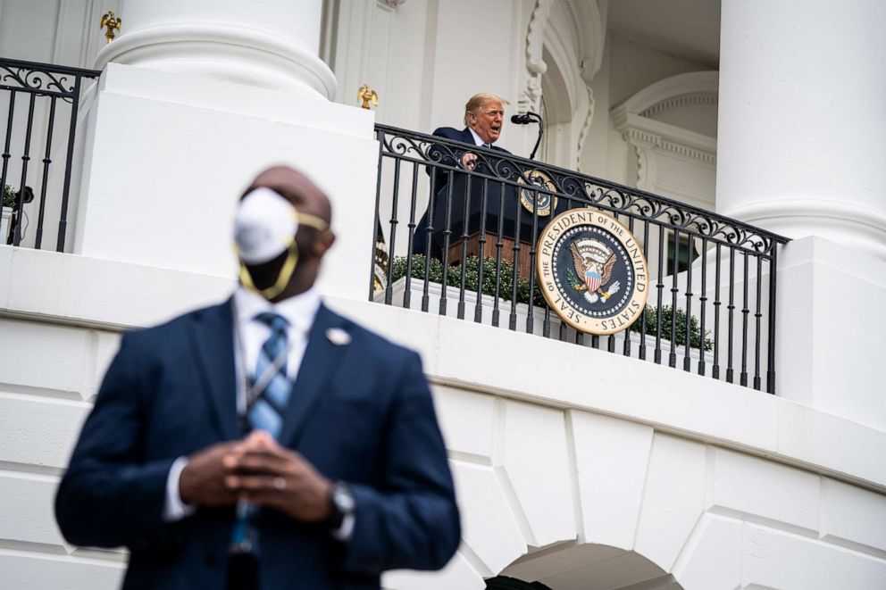 PHOTO: A member of the United States Secret Service wears a face mask while standing guard as President Donald Trump speaks to supporters from the Blue Room balcony during an event at the White House, Oct. 10, 2020, in Washington.