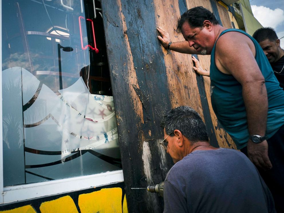 PHOTO: Men board up a shops windows ahead of the arrival of Tropical Storm Dorian in Boqueron, Puerto Rico, Aug. 27, 2019.