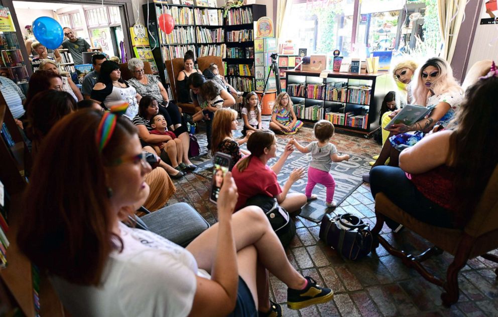 PHOTO: Drag queens Scalene Onixxx and Athena Kills read to people gathered for Drag Queen Story Hour at Cellar Door Books in Riverside, Calif., on June 22, 2019.