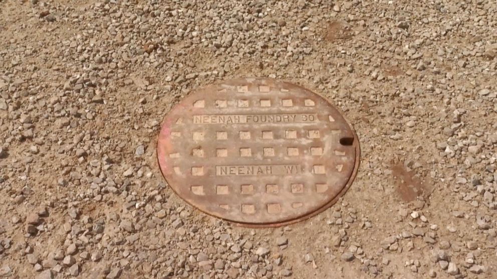 PHOTO: A finger of an 11-year-old boy poking through a manhole cover alerts rescuers to help save him from a drain pipe after he was swept away by floodwaters in Calumet County, Wis.