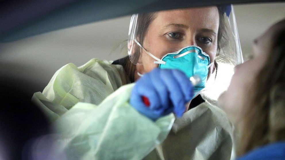 PHOTO: Dawn Canova, clinical manager for outpatient wound care at Carroll Hospital takes samples from people to test them for the coronavirus at a drive-thru station in the hospital's parking garage, March 16, 2020, in Westminster, Md.