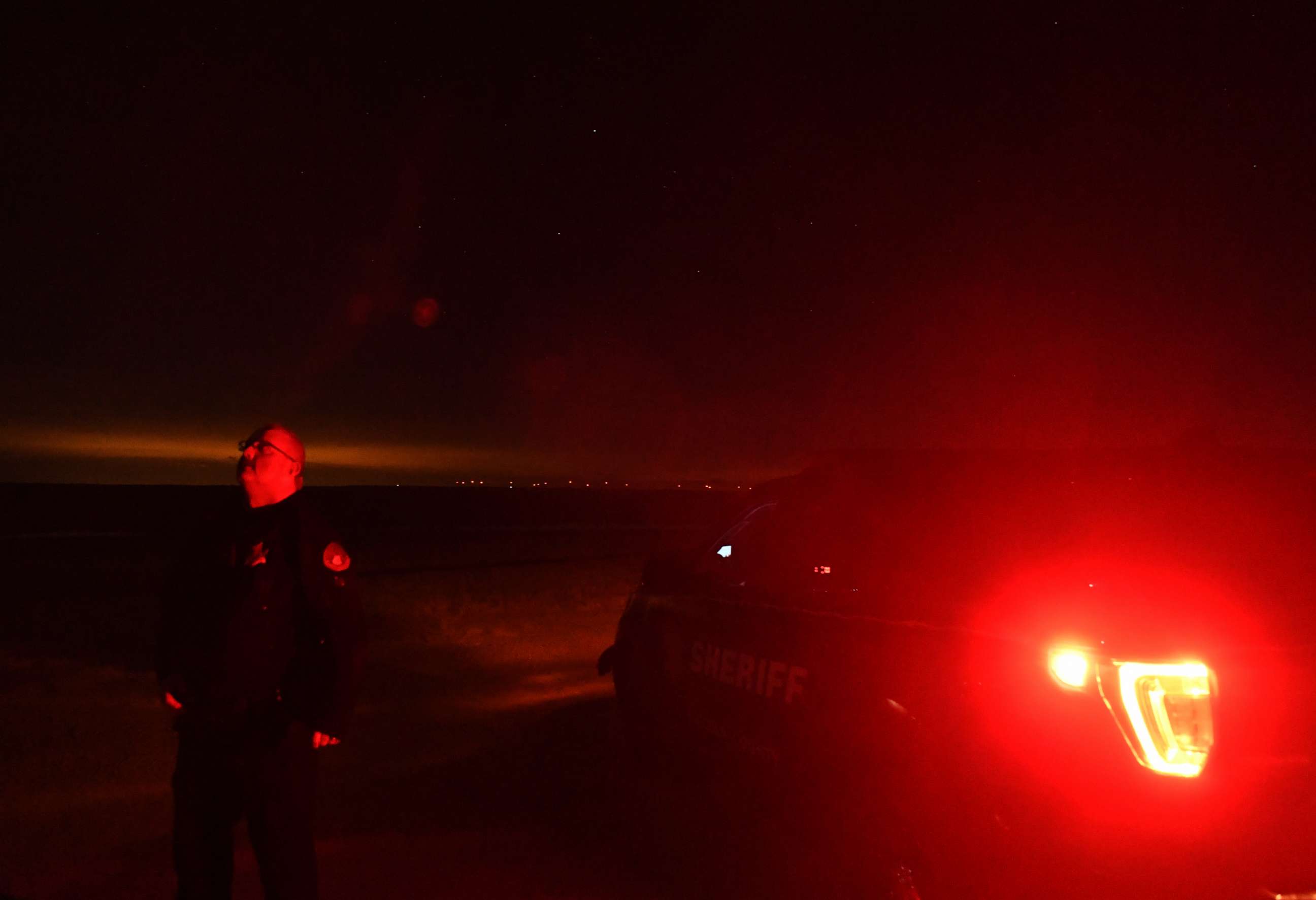 PHOTO: Lincoln County Sheriff Deputy Justin Allen stands outside of his squad car looking up at the night sky on Jan. 2, 2020 near Limon, Colo.