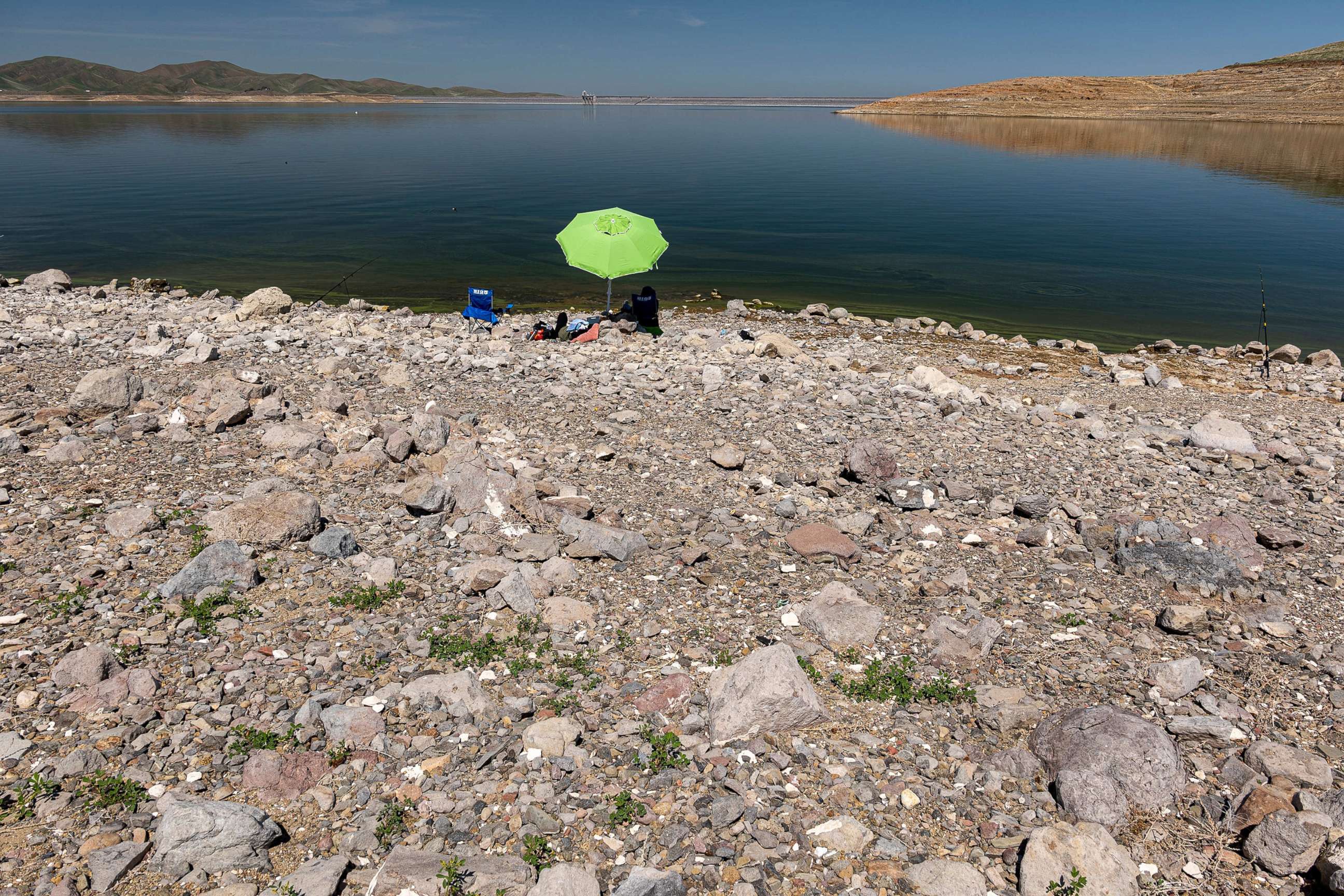 PHOTO: People sit on a dried lake bed at the San Luis Reservoir in Merced County, Calif., April 6, 2021.