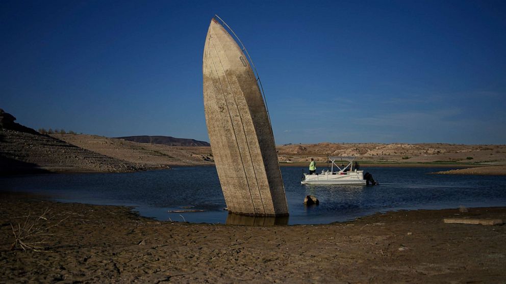 PHOTO: A formerly sunken boat sits upright into the air with its stern stuck in the mud along the shoreline of Lake Mead at the Lake Mead National Recreation Area, near Boulder City, Nev., June 10, 2022.