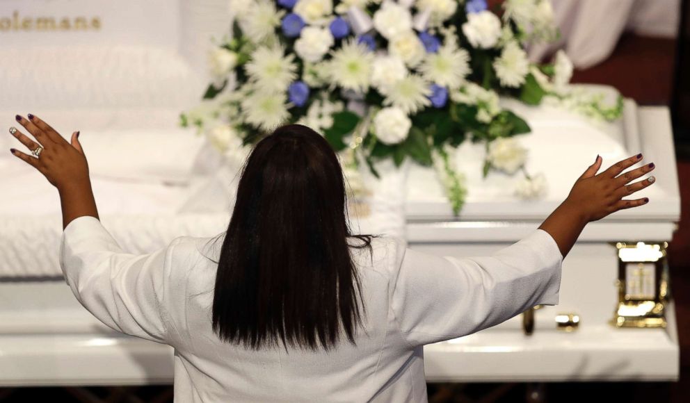 PHOTO: Tia Coleman stands during a musical selection during a funeral for her husband, Glenn Coleman and children, Reece Coleman, Evan Coleman and Arya Coleman, July 27, 2018, in Indianapolis.