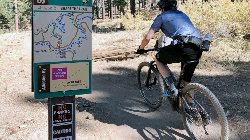 PHOTO: In this photo taken Sept. 23, 2018, a mountain biker pedals past a No E-bikes sign in the San Bernardino National Forest near Big Bear Lake, Calif.