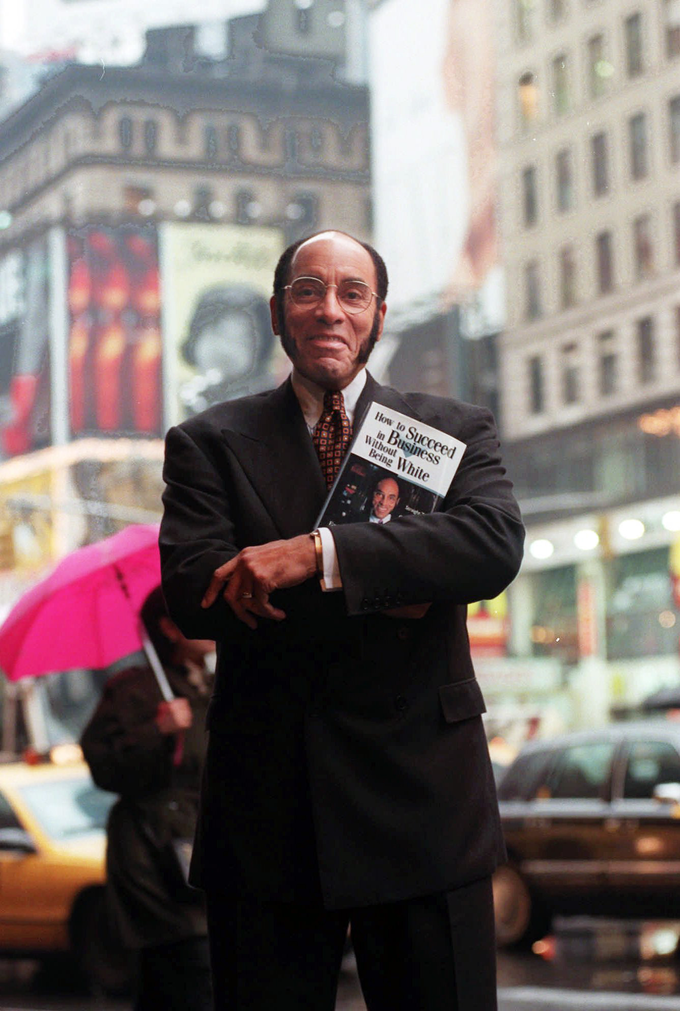 PHOTO: Publisher and CEO of Black Enterprise Magazine Earl G. Graves poses with his book "How To Succeed In Business Without Being White" in Times Square in New York, April 17, 1997.
