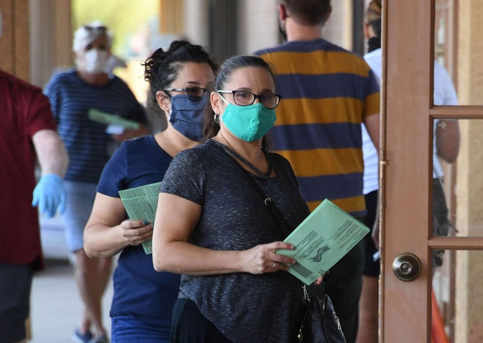 PHOTO: People wait in line to drop off mail-in ballots at an early voting location in Phoenix, on Oct. 16, 2020.