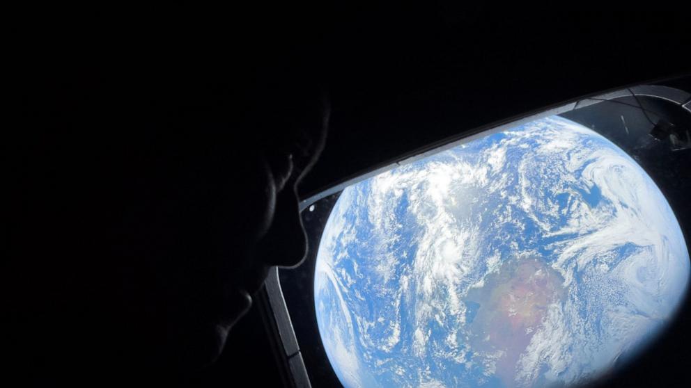 PHOTO: Commander Reid Wiseman gazes at Earth from Orion’s windows, a reminder of home as they travel toward the moon.