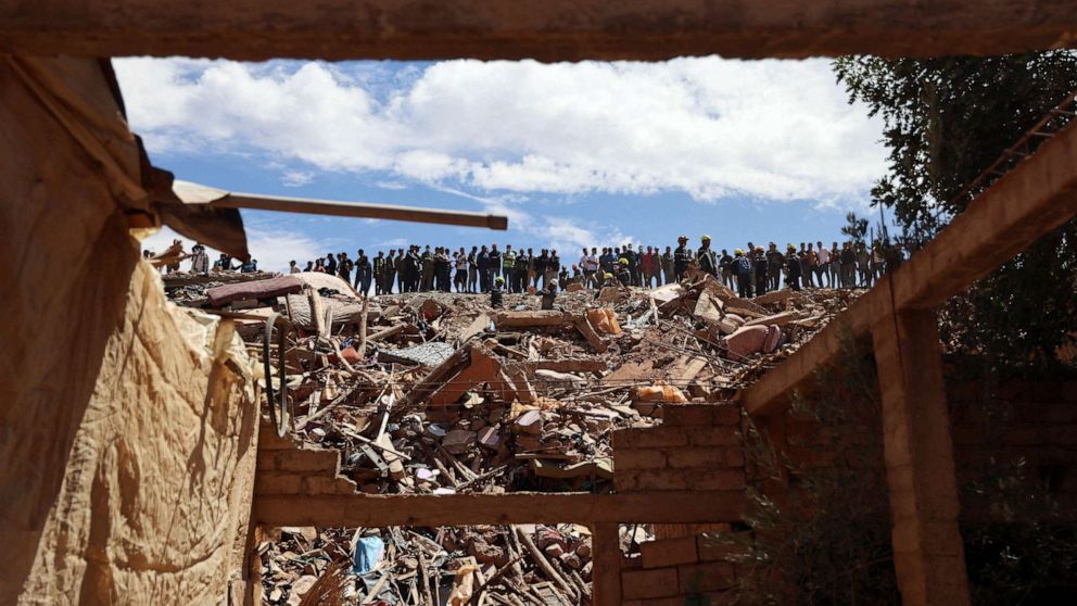 PHOTO: People watch as firefighters work on the rubble in the aftermath of a deadly earthquake in Tallat n'Yakoub, Morocco, Sept. 12, 2023.