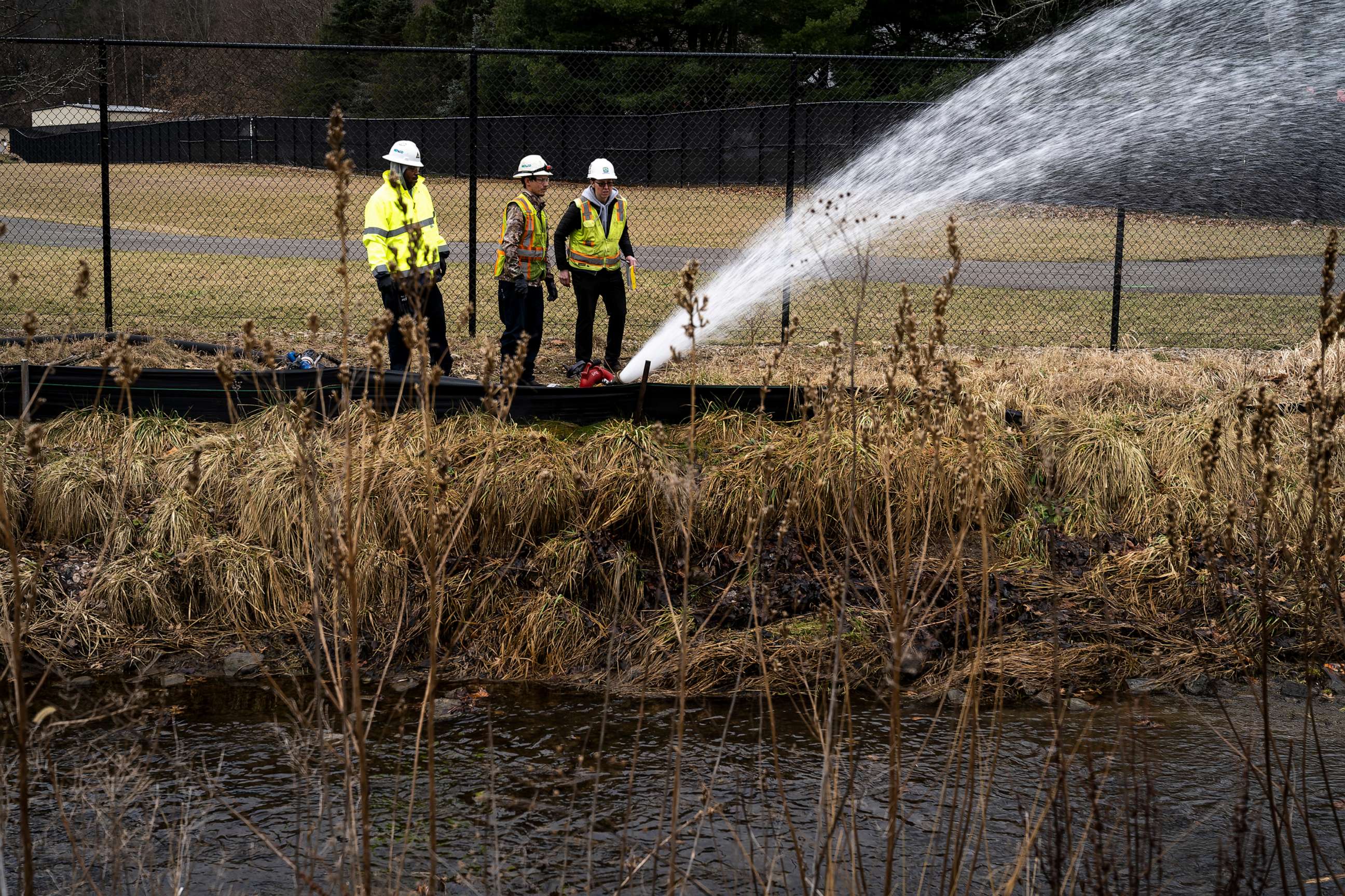 PHOTO: A clean-up crew works alongside a stream as clean-up efforts continue on Feb. 16, 2023, in East Palestine, Ohio. On Feb. 3rd, a Norfolk Southern Railways train carrying toxic chemicals derailed causing an environmental disaster.
