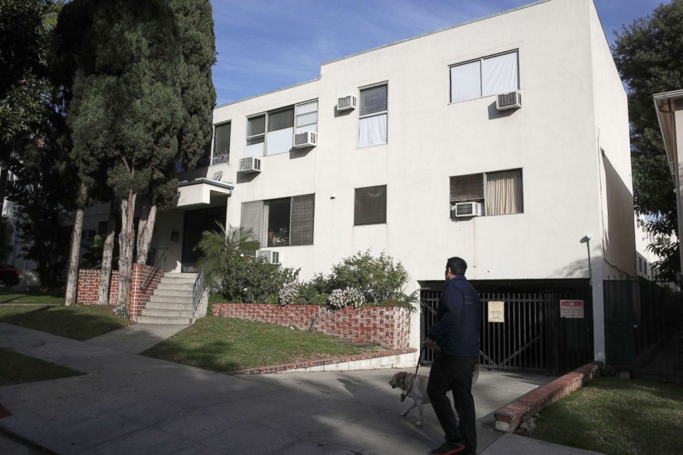 PHOTO: A man walks his dog past an apartment building, Jan. 8, 2019, where an unidentified man died in the apartment of Democratic Party donor Ed Buck, in West Hollywood, Calif.