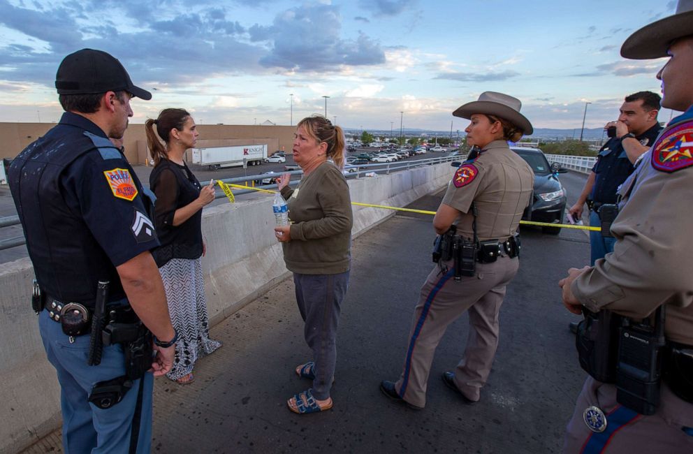 PHOTO: Edie Hallberg, center, speaks with police officers outside the Walmart store as she's looking for her missing mother Angie Englisbee, 87, who was in the store during the shooting in El Paso, Texas, Aug. 3, 2019.