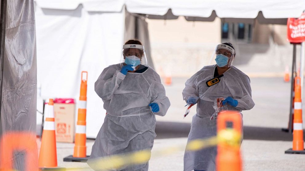 PHOTO: Medical personnel administer free COVID-19 tests at a state run drive-through testing site in the parking lot of the University of Texas, El Paso campus, in El Paso, Texas, U.S., Nov. 23, 2020.