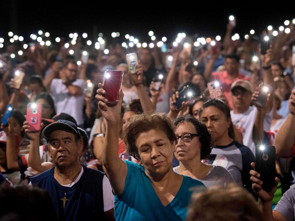 PHOTO: People hold up their phones during a prayer and candle vigil organized by the city, after a shooting at the Cielo Vista Mall Wal-Mart in El Paso, Texas, Aug. 4, 2019.