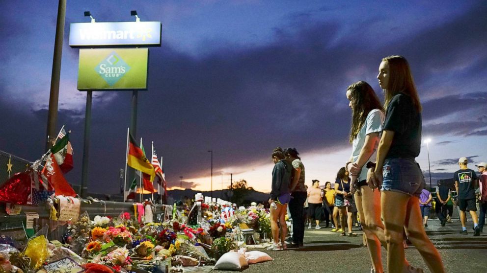 PHOTO: People gather at a makeshift memorial honoring victims outside Walmart in El Paso, Texas, Aug. 15, 2022.