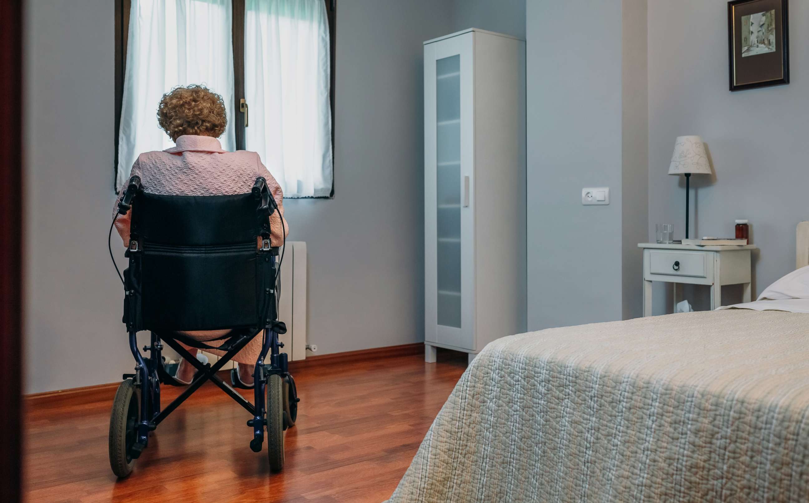 An elderly person sits in a wheelchair. 