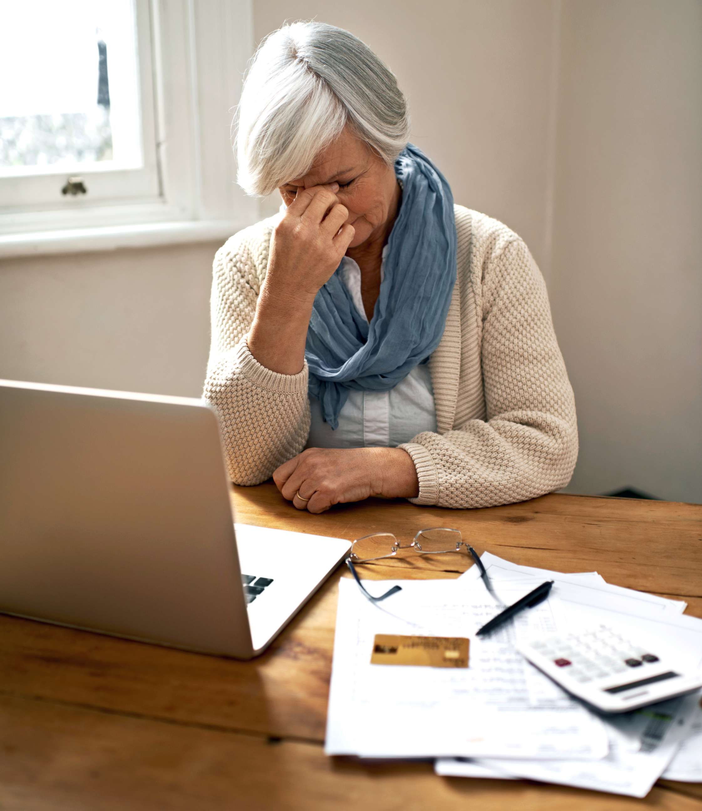 PHOTO: A senior woman sitting in front of a laptop and bills appears in this undated stock photo.