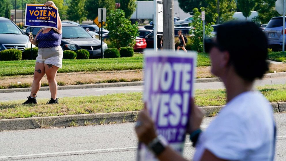 PHOTO: Kansans for and against the Constitutional Amendment on Abortion hold up signs along 135th Street in Olathe, Kansas, Aug. 1, 2022