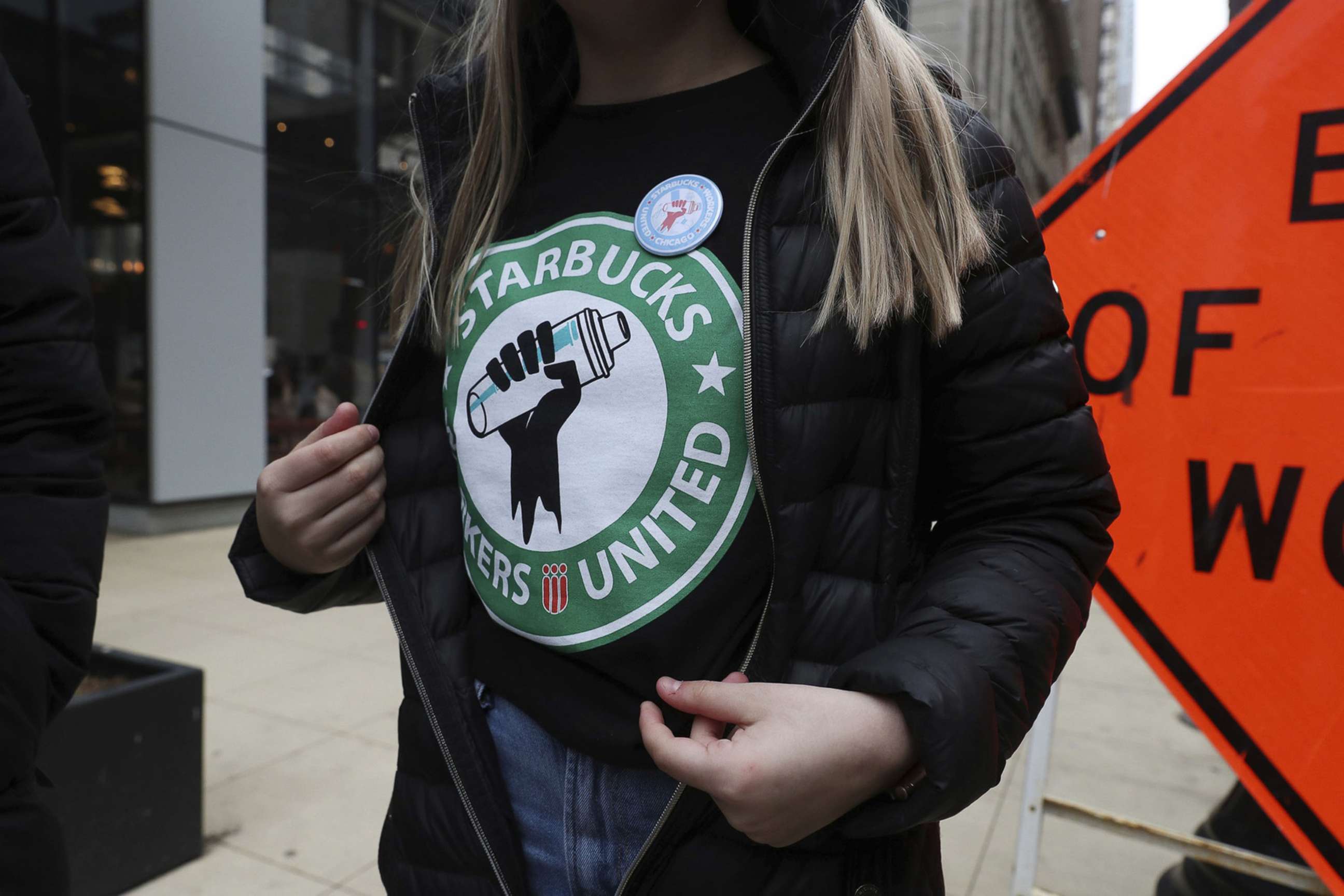 PHOTO: Starbucks worker Kaylie McKinley wears a t-shirt and button promoting unionization, outside a Chicago location, April 7, 2022.