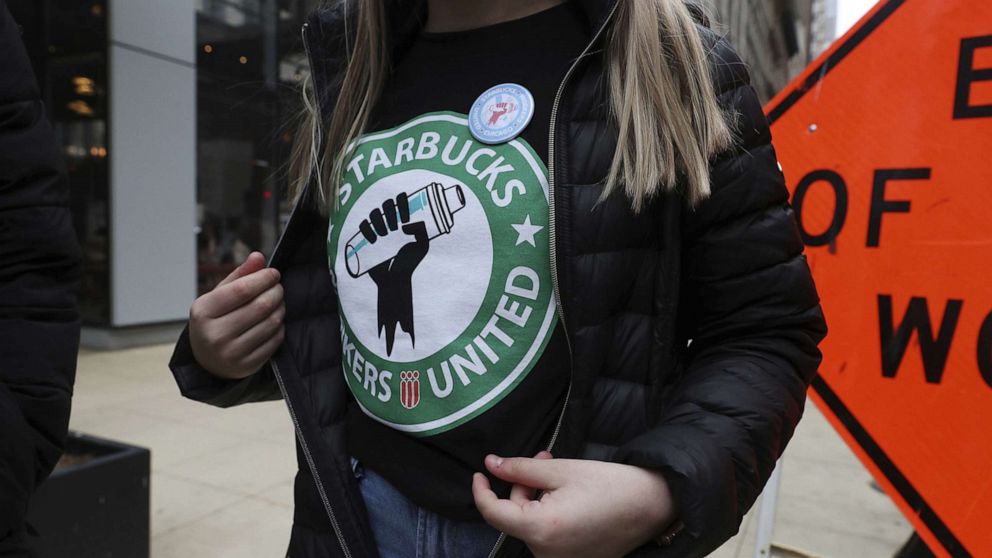 PHOTO: Starbucks worker Kaylie McKinley wears a t-shirt and button promoting unionization, outside a Chicago location, April 7, 2022.