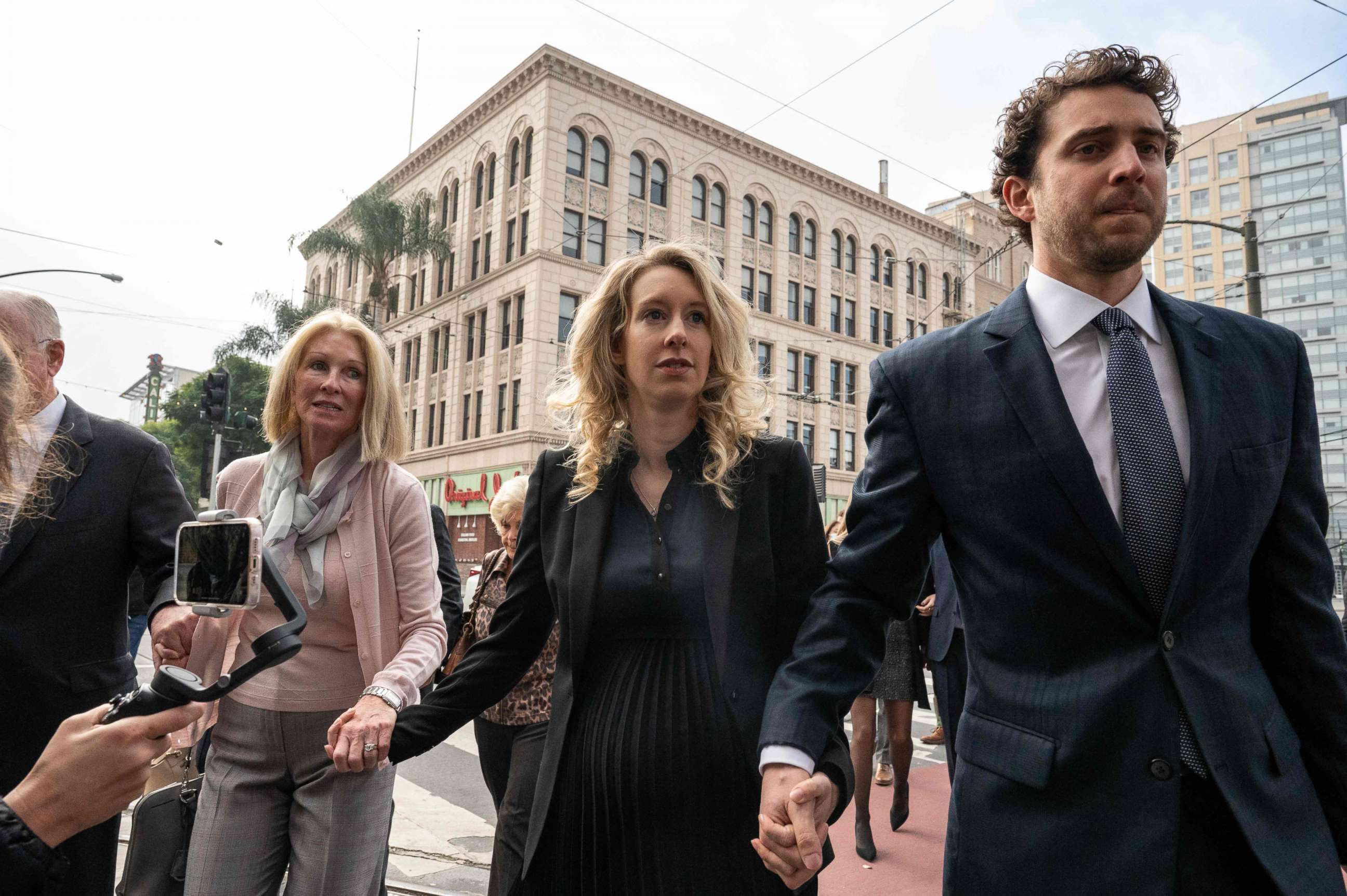 PHOTO: Elizabeth Holmes, founder and former CEO of blood testing and life sciences company Theranos, walks with her mother Noel Holmes and partner Billy Evans into the federal courthouse for her sentencing hearing on Nov. 18, 2022 in San Jose, Calif.