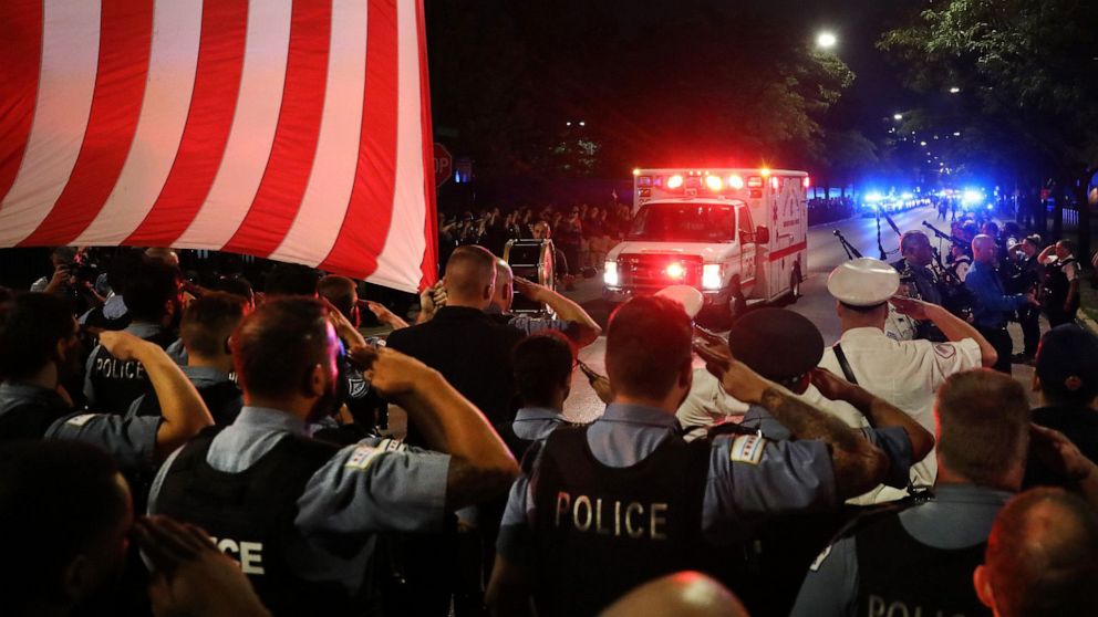 PHOTO: Chicago police officers salute as the ambulance carrying the body of Officer Ella French arrives at the Cook County medical examiner, Aug. 8, 2021.