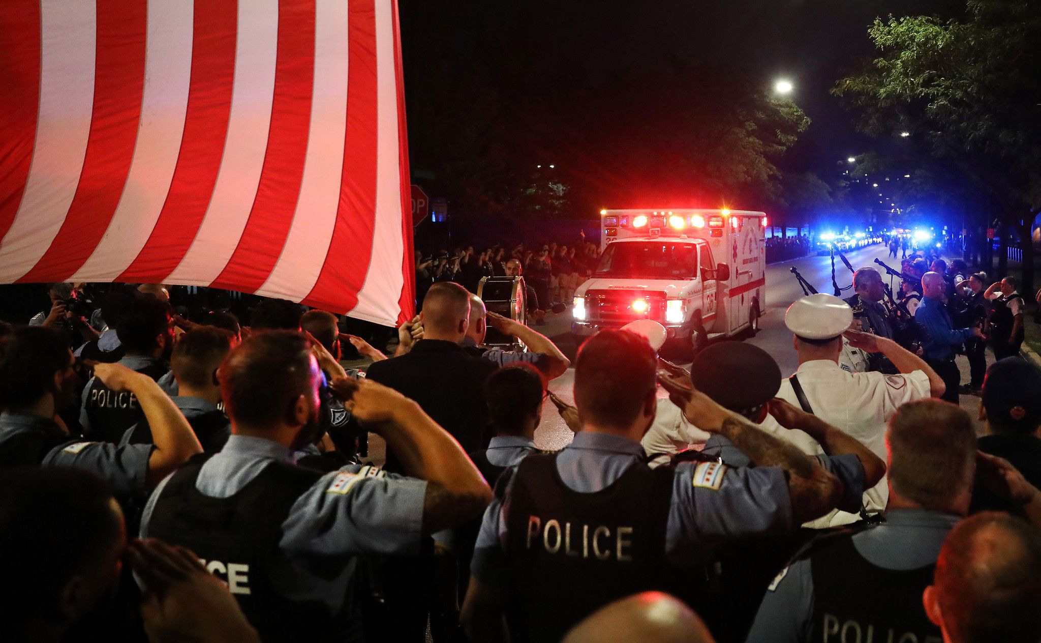 PHOTO: Chicago police officers salute as the ambulance carrying the body of Officer Ella French arrives at the Cook County medical examiner, Aug. 8, 2021.