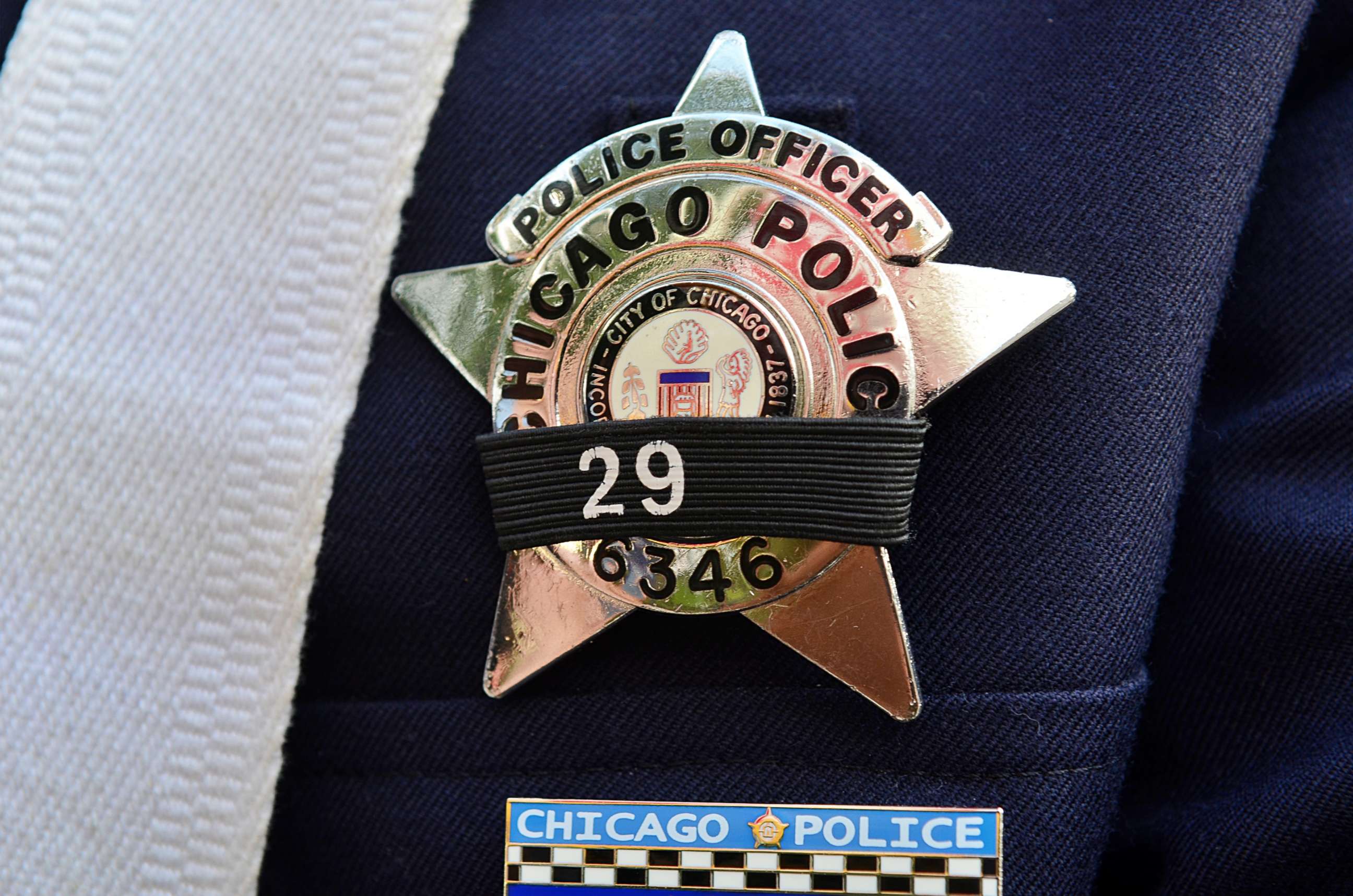 PHOTO: A police officer's badge is covered in a black band at a prayer vigil in remembrance of Police Officer Ella French and her wounded partner on Aug. 11, 2021, in Chicago.
