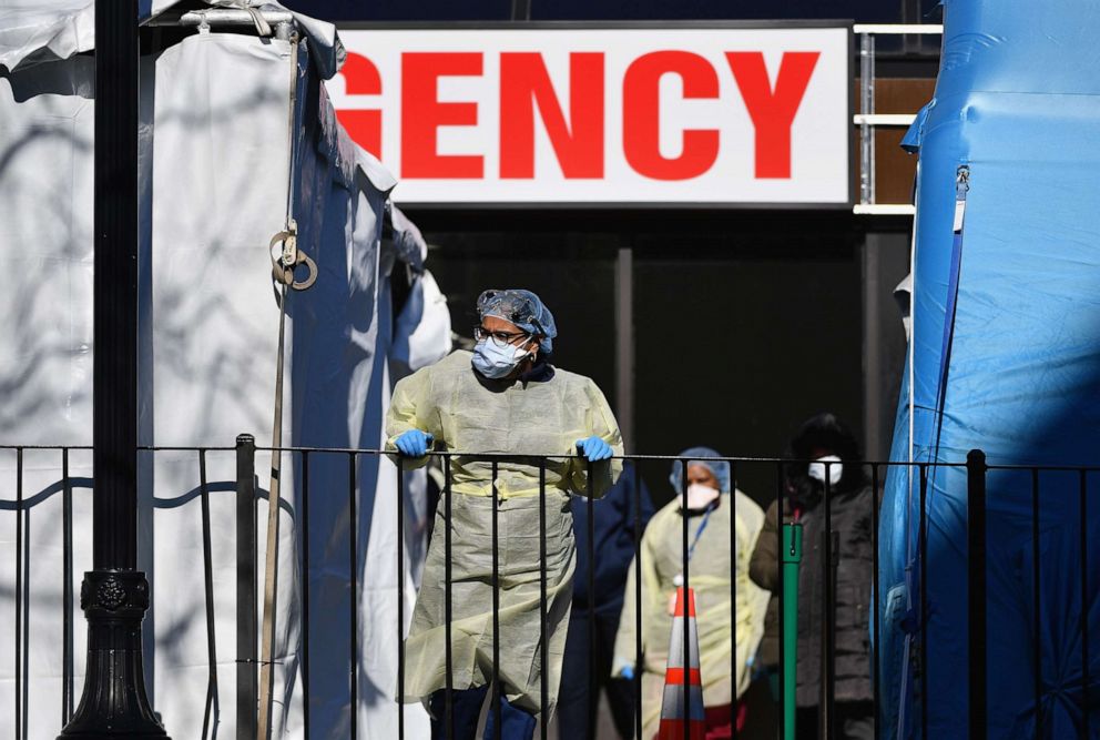 PHOTO: Medical workers stand outside at Elmhurst Hospital Center in the Queens borough of New York City on March 26, 2020.