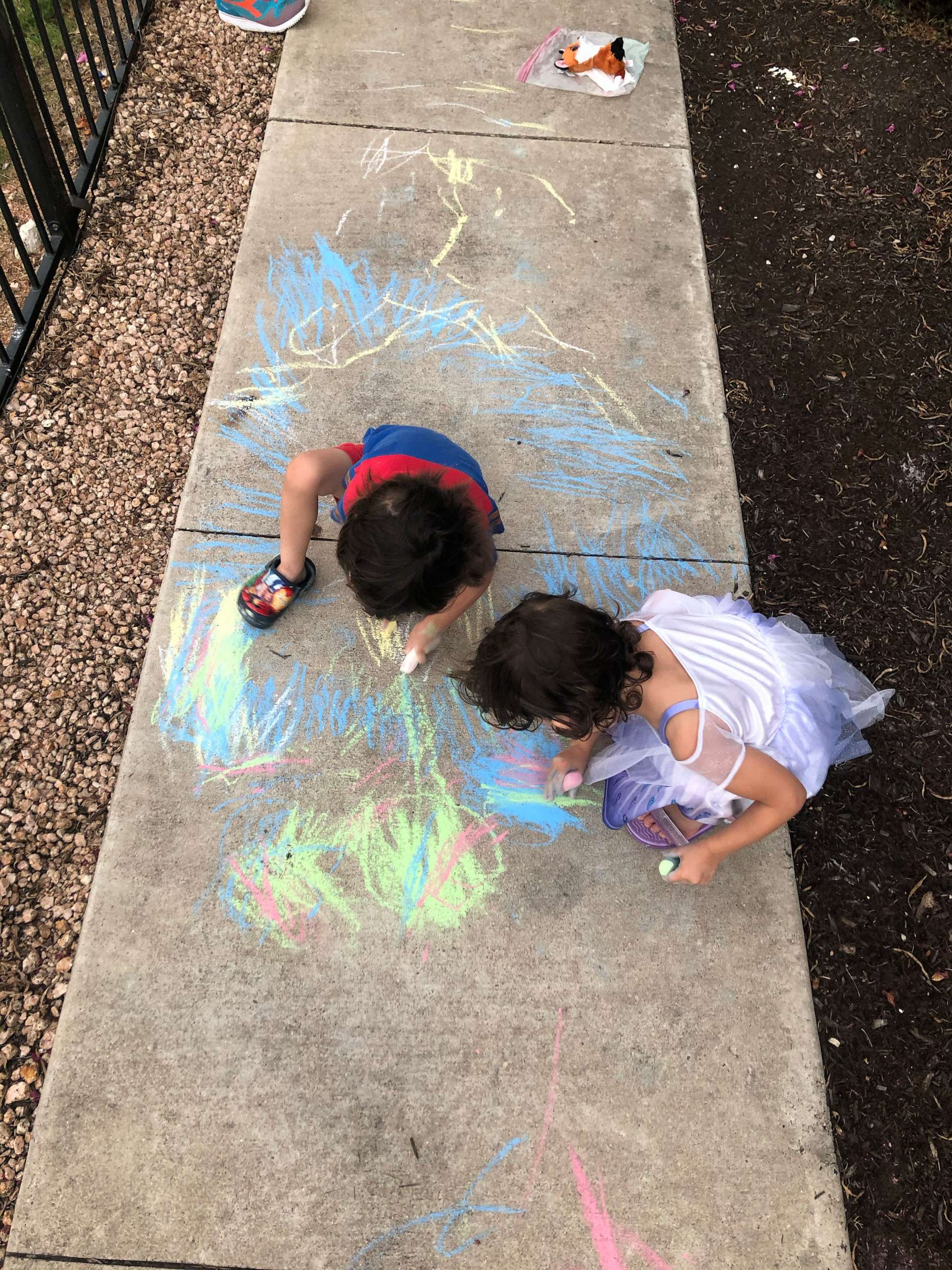 PHOTO: Elsa, a trans girl, can be seen drawing on the sidewalk with her sibling.