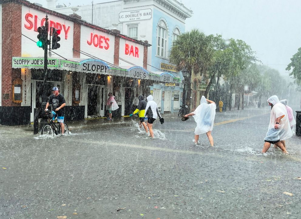 PHOTO: Visitors head for Sloppy Joe's Bar while crossing a flooded Duval Street as heavy winds and rain pass over Key West, Fla., July 6, 2021.