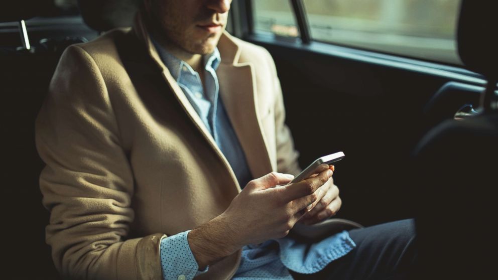 A man using smart phone in the car.