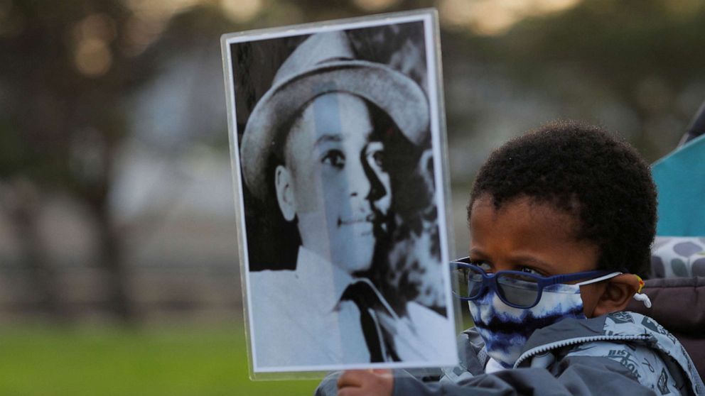 PHOTO: A young boy holds a photograph of Emmett Till, a 14-year-old Black boy who was lynched in 1955, at a vigil on the one year anniversary of the murder of George Floyd while in Minneapolis police custody, in Lynn, Massachusetts, May 25, 2021.