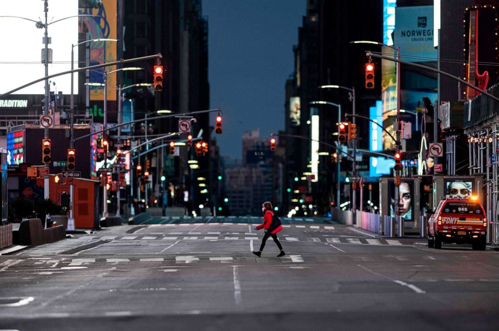 PHOTO: A woman walks through an almost-deserted Times Square in the early morning hours, April 23, 2020, in New York.