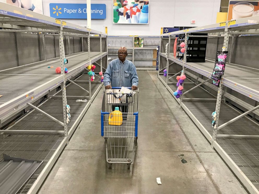 PHOTO: A shopper walks down an aisle that's normally stocked with toilet paper and other paper products at Walmart in Milwaukee, Wis., March 16, 2020.  The impact of the coronavirus pandemic is causing area store's paper stock to become depleted. 