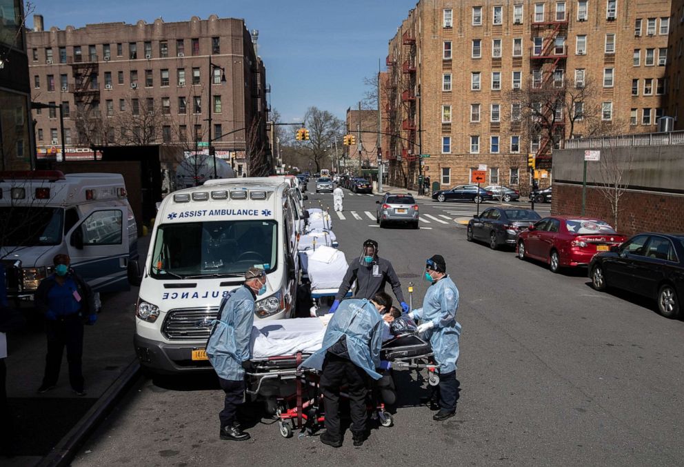 PHOTO: Medics and hospital workers prepare to lift a COVID-19 patient onto a hospital stretcher outside the Montefiore Medical Center Moses Campus, April 7, 2020 in the Bronx borough of New York City.