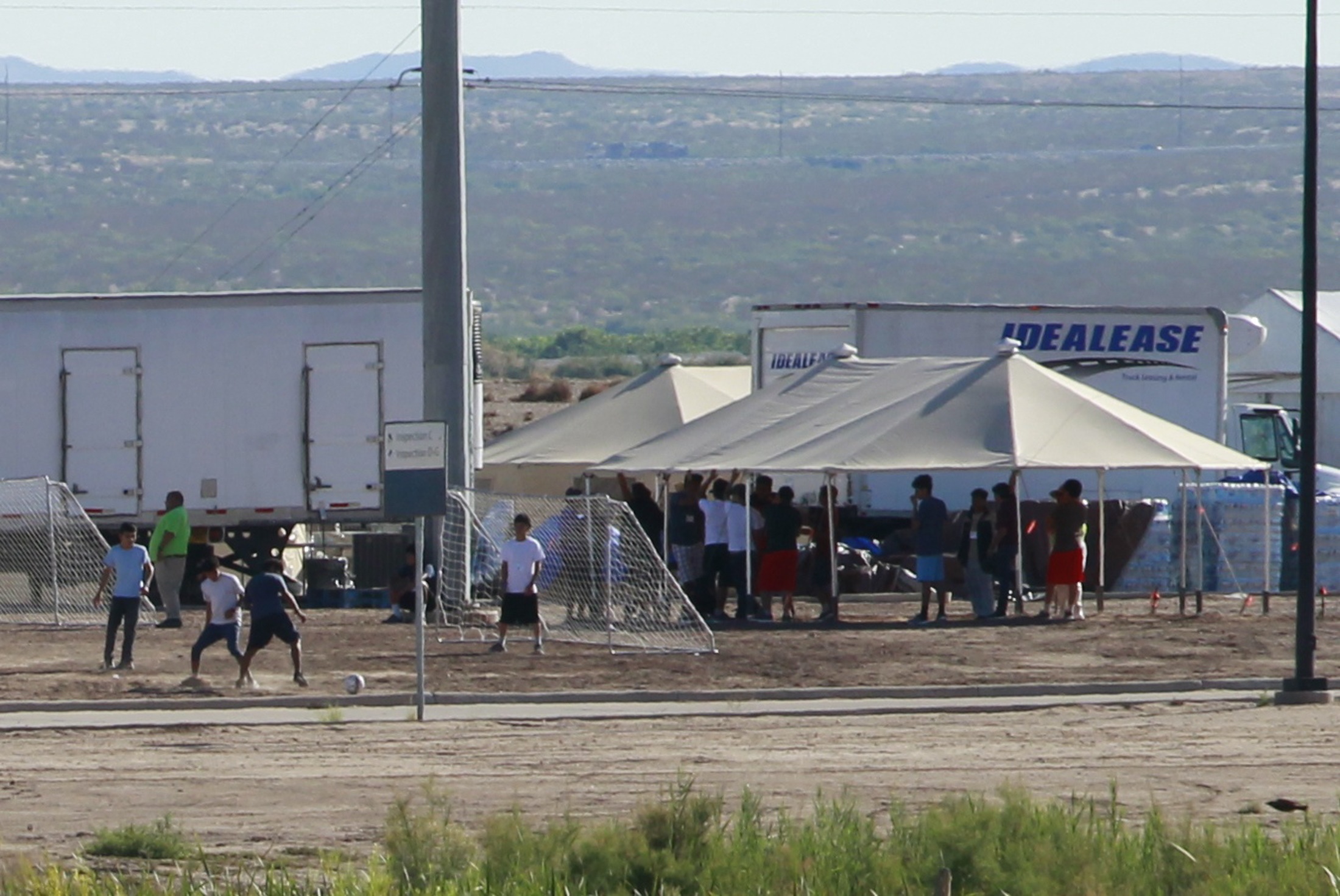 PHOTO: Children of detained migrants play soccer at a newly constructed tent encampment as seen through a border fence near the U.S. Customs and Border Protection port of entry in Tornillo, Texas, June 18, 2018.