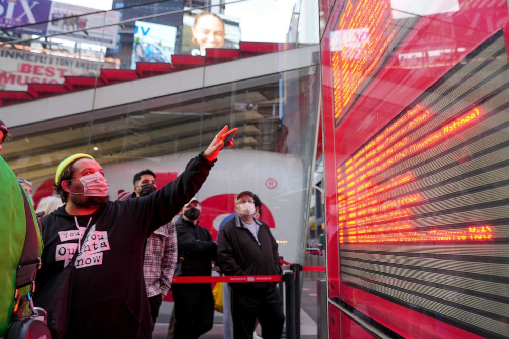 PHOTO: A man points at a chart with Broadway shows in the theatre district showing some of the major musicals as having some shows cancelled due to Covid-19 in New York, Dec. 17, 2021. 