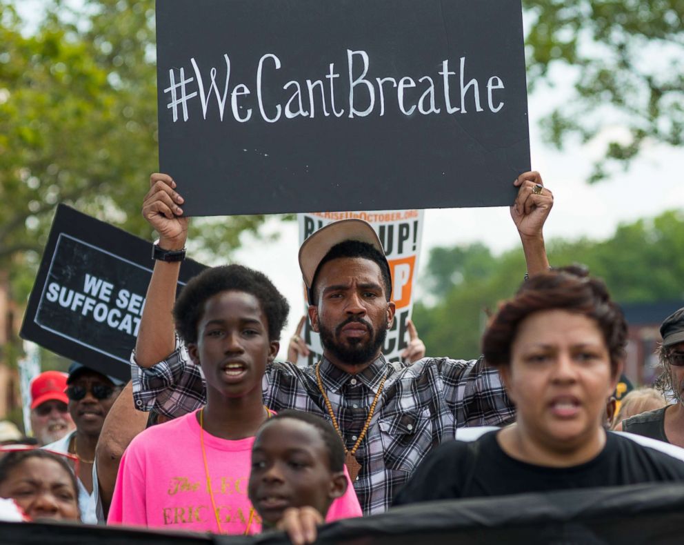 PHOTO: Rally participants hold signs while marching in Staten Island, N.Y., on the second anniversary of the death of Eric Garner, July 17, 2017.