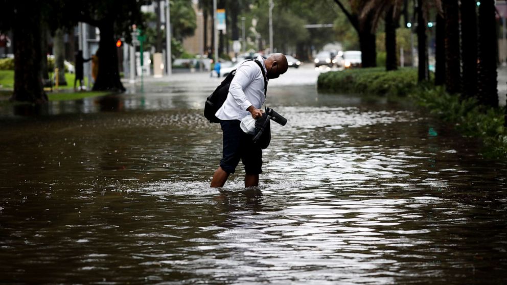 PHOTO: A man walks in floodwaters caused by Storm Eta in a street at the Brickell neighborhood in Miami, Nov. 9, 2020.