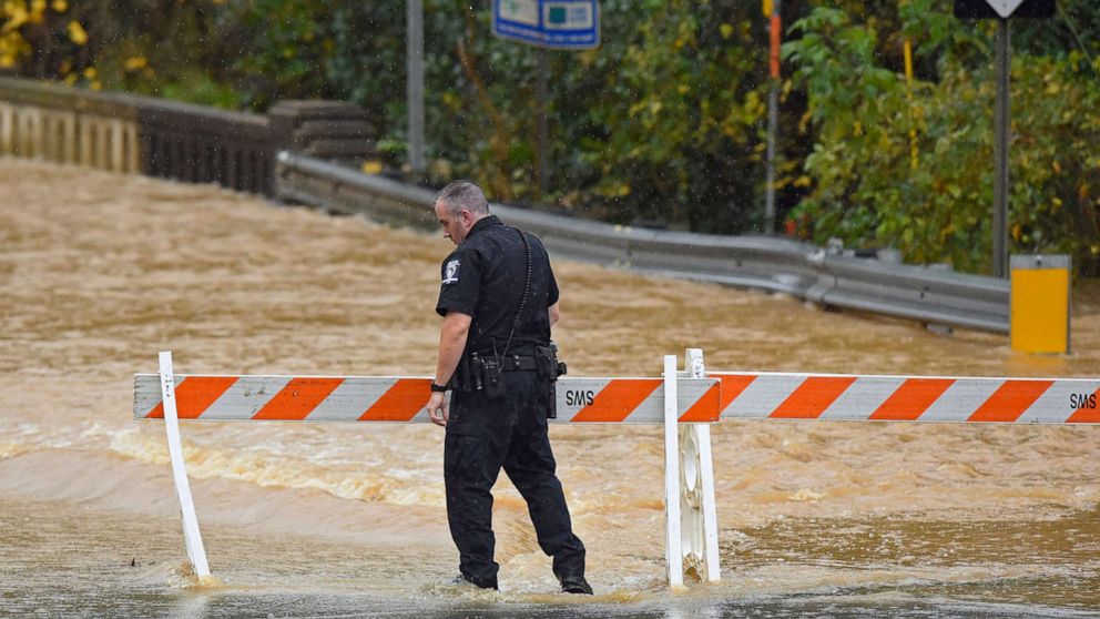 PHOTO: A Charlotte-Mecklenburg police officer blocks West Blvd. from local traffic as floodwater blocks the road in Charlotte, N.C., Thursday, Nov. 12, 2020.