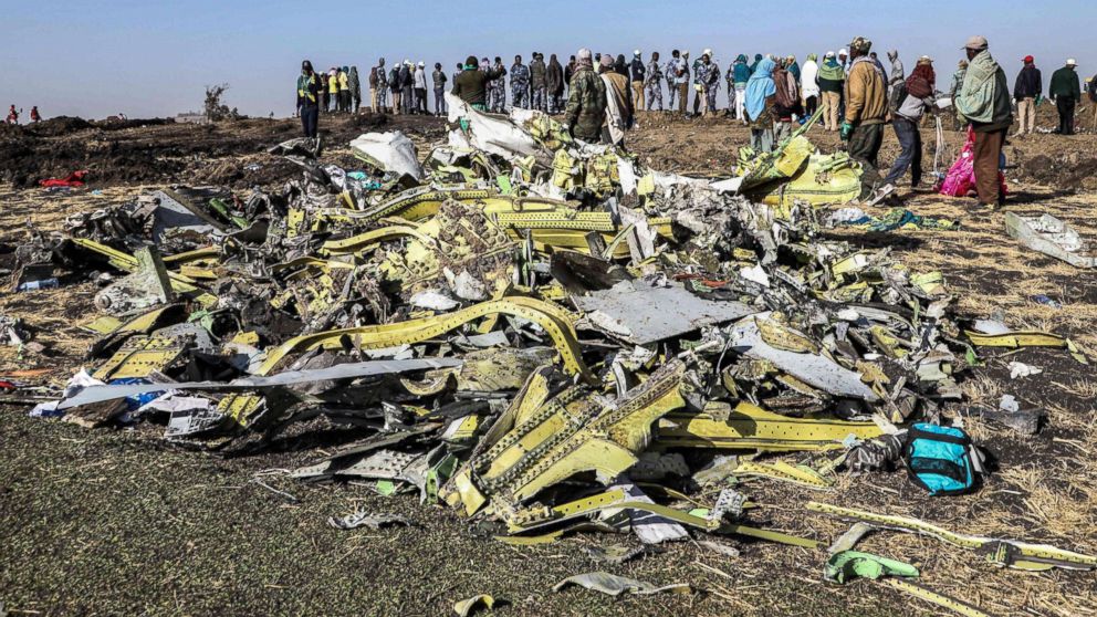 People stand near collected debris at the crash site of Ethiopia Airlines near Bishoftu, southeast of Addis Ababa, Ethiopia, March 11, 2019.