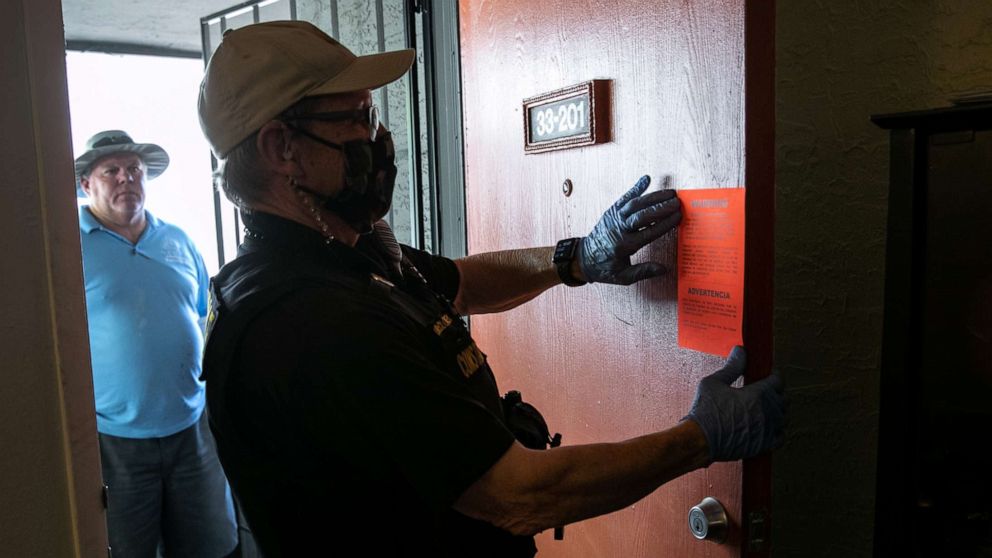 PHOTO: Maricopa County constable Lenny McCloskey posts an eviction order on the door of an apartment Sept. 30, 2020, in Glendale, Arizona.