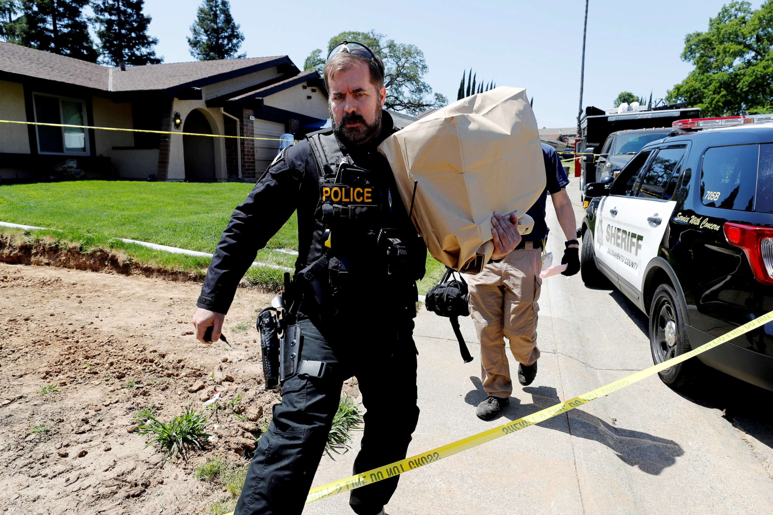 PHOTO: A police officer removes items in evidence bags from the home of Joseph James Deangelo, in Citrus Heights, Calif, April 26, 2018.